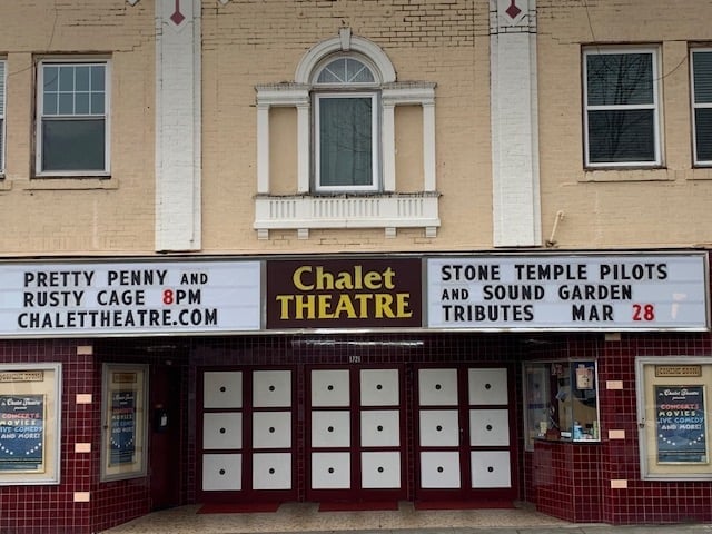 Chalet Theatre facade with marquee displaying upcoming performances and boarded-up box office windows