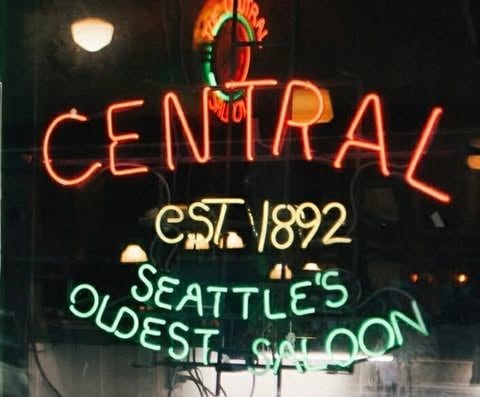 Neon sign for Central Saloon, Seattles oldest saloon established 1892, with glowing red and green lettering against dark background